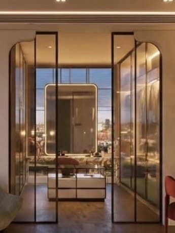 Arched black-framed glass doors opening onto a lit dressing area with a rounded mirror.